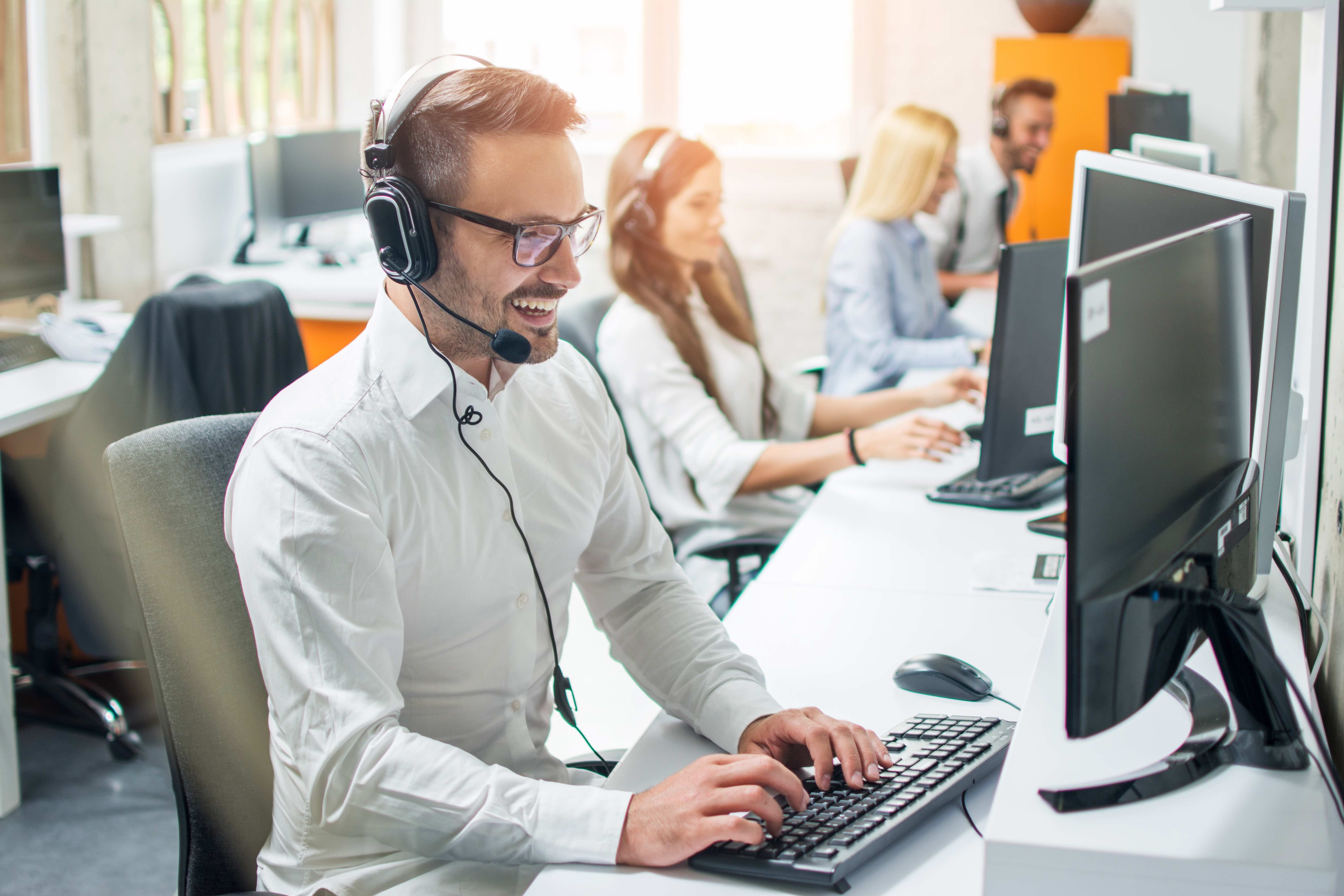 man offering technical support at desk