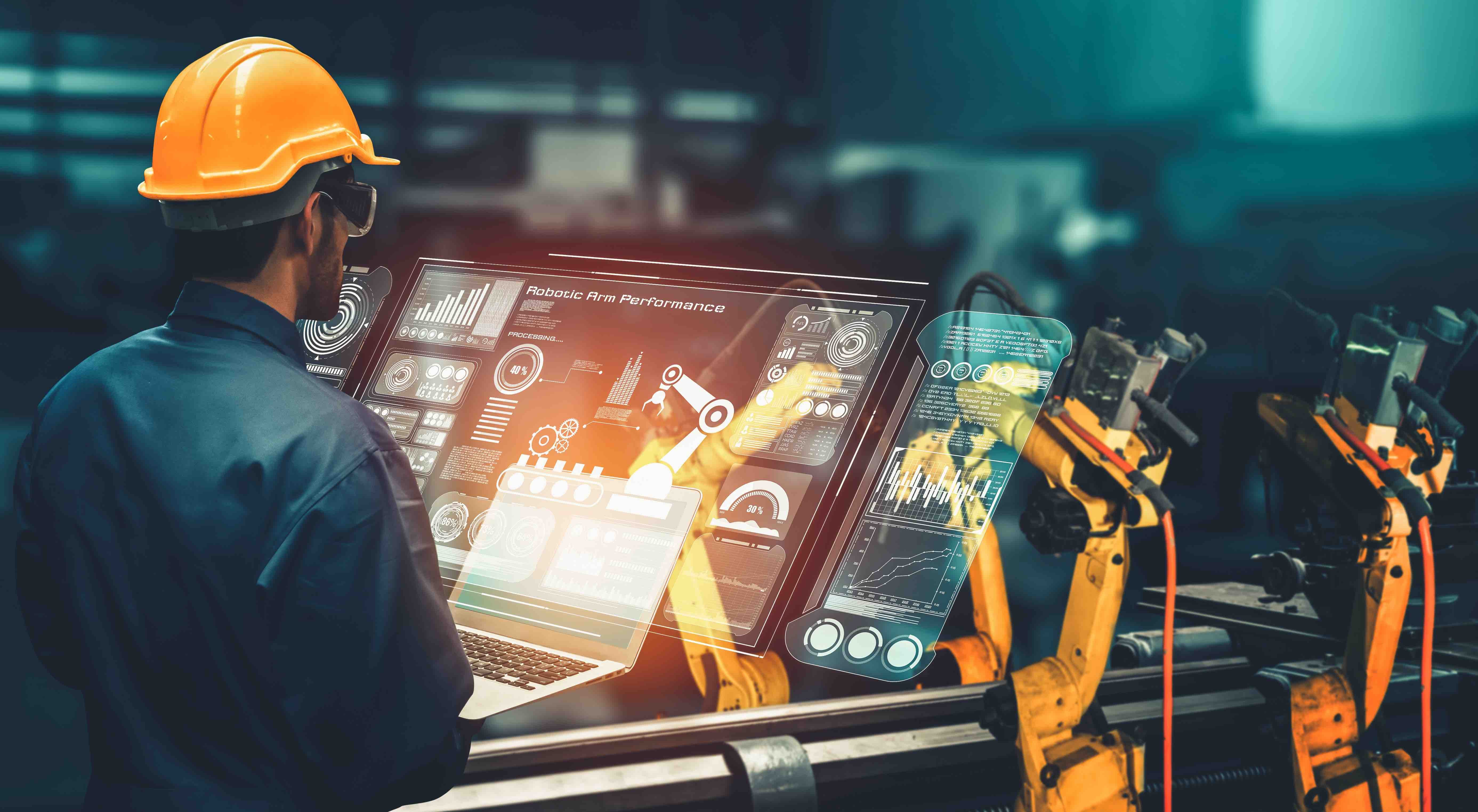 man in hard hat looks at digital screen for manufacturing